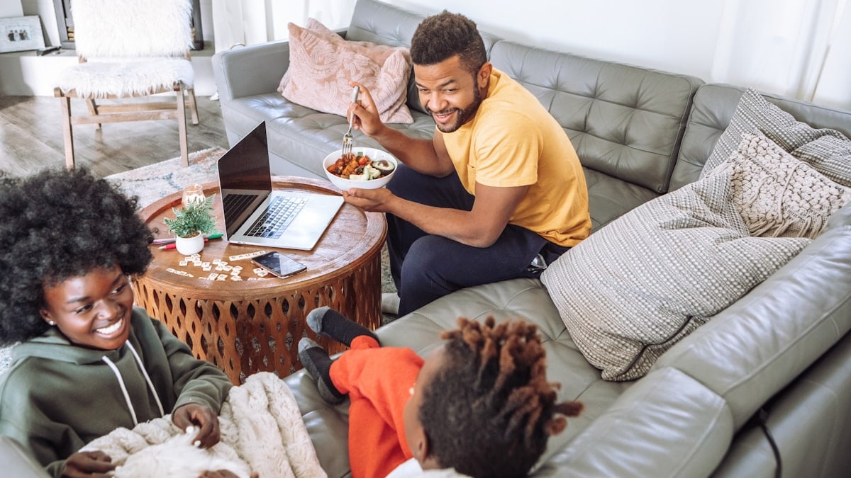 man in yellow crew neck t-shirt sitting on brown wooden chair